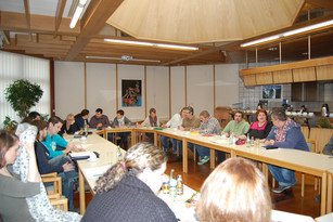 Das Treffen des Koa-Arbeitskreises: Menschen sitzen zusammen am Tisch und diskutieren